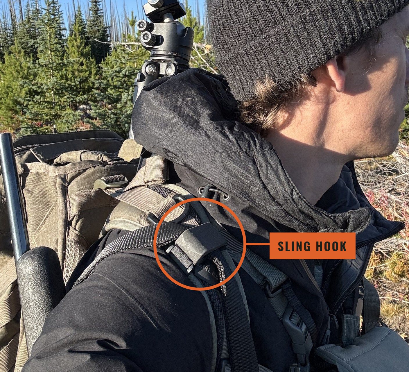 Hunter hiking with a rifle held on his backpack strap by the Sling Hook